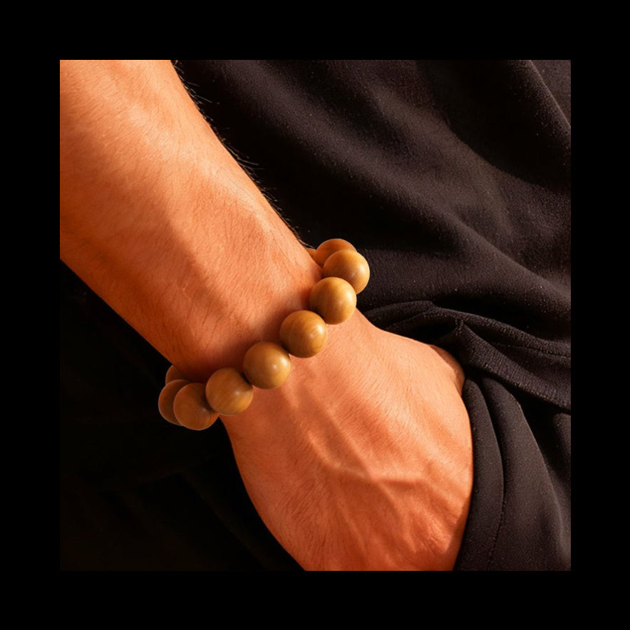 Wooden beaded bracelet on a wrist against a black background